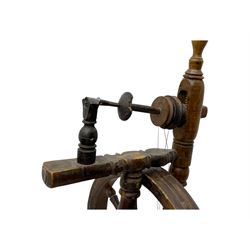 Late 19th century turned beech spinning wheel, upright form with single treadle, triangular base, and a flyer and bobbin assembly surmounted by a turned finial.