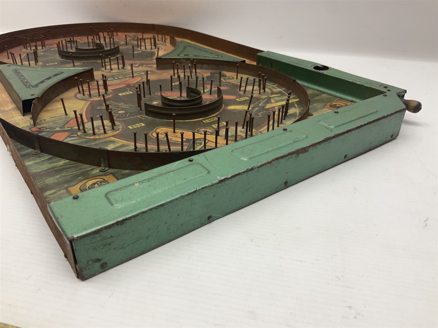 1934 Lindstrom's 'Airways' tin-plate bagatelle game by Lindstrom Tool and Toy Company Bridgeport Conn., the decorative bagatelle board depicting Lindstrom's epic airway routes; with wooden peg and quantity of balls H61cm