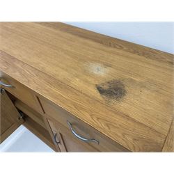 Light oak sideboard, three drawers above three cupboards enclosing shelving, stile supports