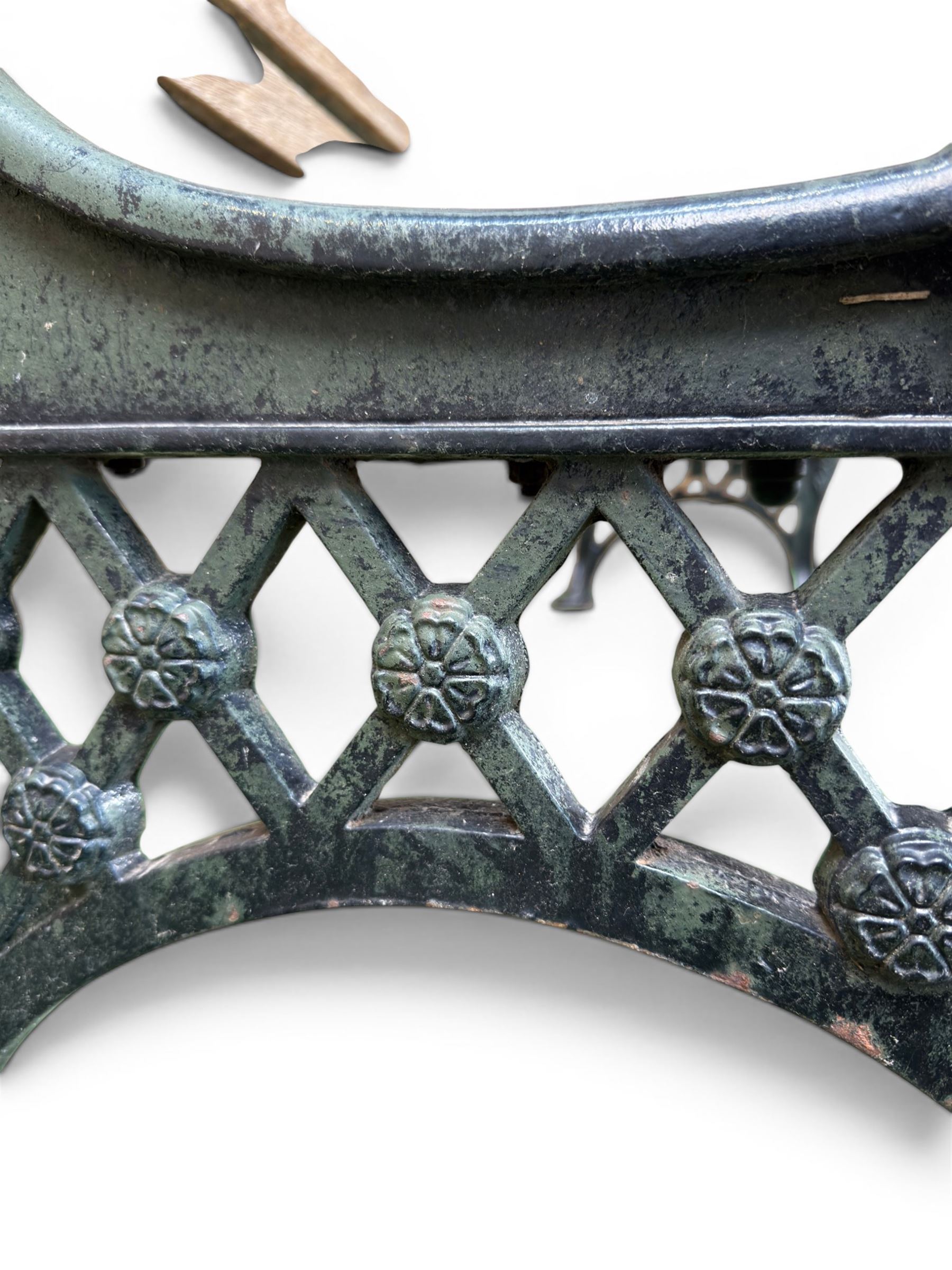 Neoclassical design cast iron and oak slatted garden bench, the twin end supports in the form of a Sphinx with acanthus carved knees and large paw feet, the pierced lattice bracket with Yorkshire rose motifs
