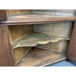 Large George III oak corner cupboard, projecting cornice over two stepped arch doors with fielded panels and blind fret work spandrels, flanked by fluted uprights, cupboard below enclosed by two fielded panel doors, the painted interior fitted with shaped shelves
 