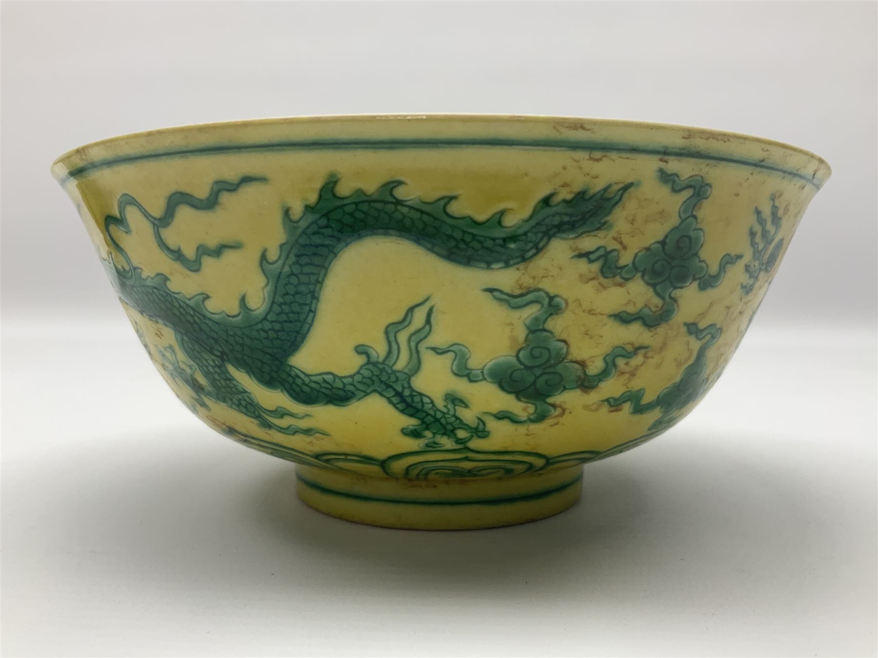 Pair of Chinese famille jaune bowls, decorated in green enamel with a dragon chasing a flaming pearl amongst clouds, upon a yellow ground, the interior decorated to centre with dragon, with six character mark beneath, D17.5cm