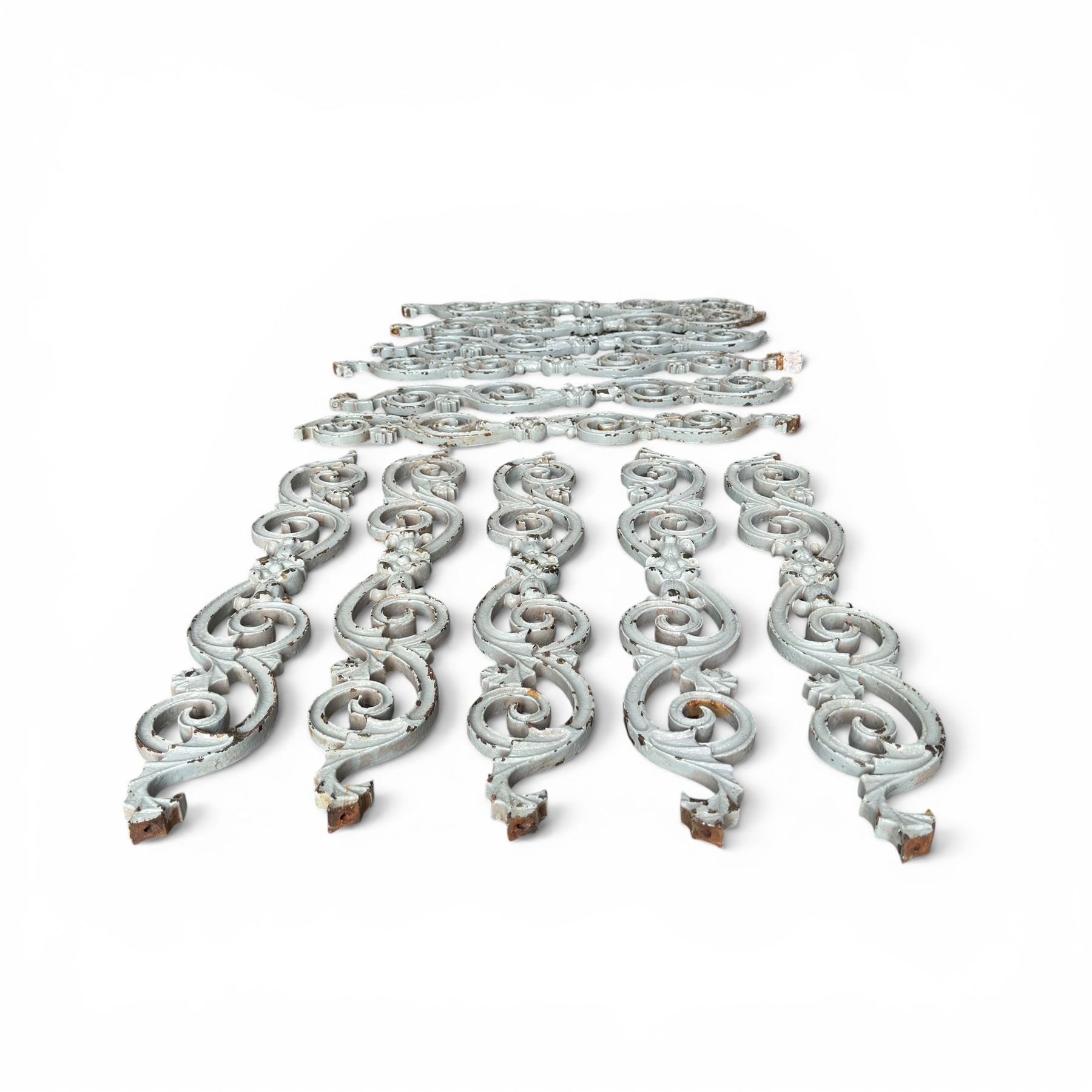 Set of eleven 19th century cast iron ornate stair or banister spindle supports, of scrolling form with scalloped decoration and flower-head motifs, in weathered duck-egg blue painted finish (11)