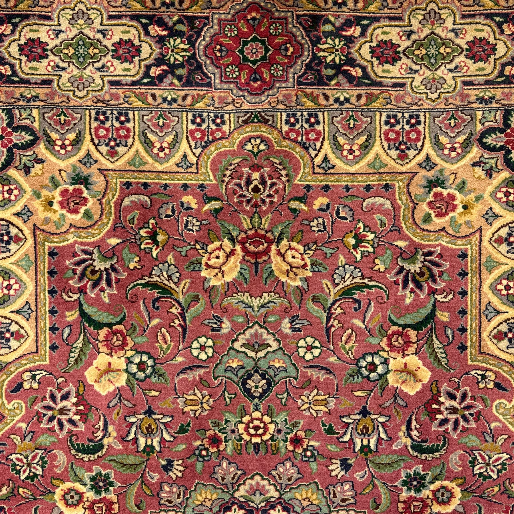 Kashan design hand knotted wool carpet, decorated with an ivory and green floral medallion on a pink ground with scrolling vines, ivory spandrels, multiple navy and ivory borders with stylised flowerheads, from the region of Punjab, Pakistan