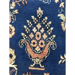 Persian Herati design indigo and red ground carpet, decorated with floral motifs, arched border