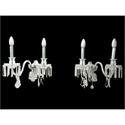 Pair of cut glass two branch wall sconce candelabras, each with S scroll extending branches with shaped and bevelled circular drip trays, hung with pendant drops
