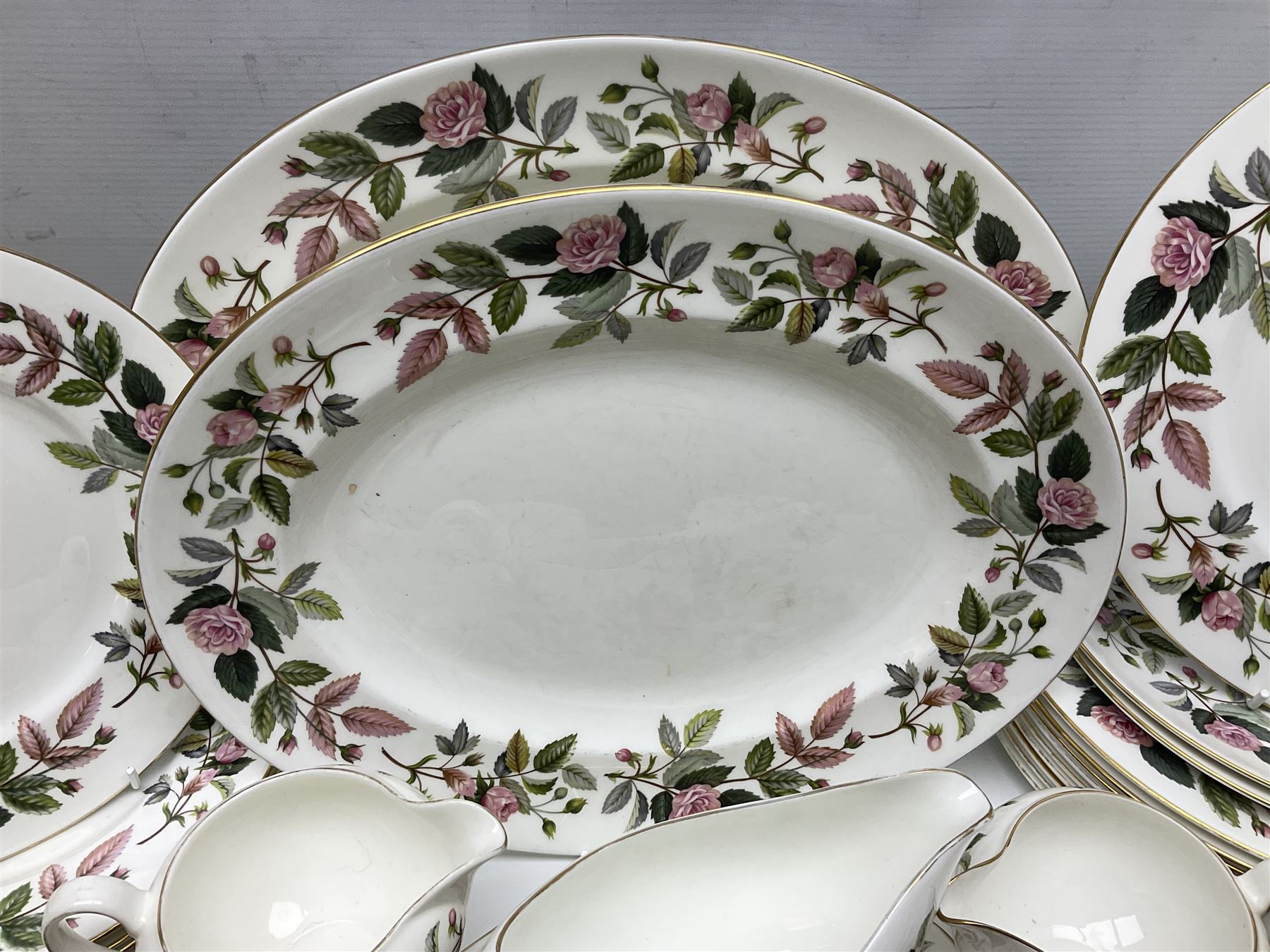 Wedgwood Hathaway Rose pattern tea and dinner wares, comprising twelve saucers, sixteen teacups, twenty tea plates, jug, sucrier, thirteen shallow bowls, sauce boat and saucer, two lidded tureens, larger jug, ten dinner plates, nine smaller plates and two large oval serving dishes