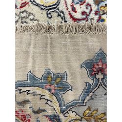 Large Persian Sarouk ivory ground carpet, central rosette medallion with a series of plant motifs, the field decorated with interlacing and hanging cartouches, surrounded by shaped border with stylised plant and flower head motif decoration 