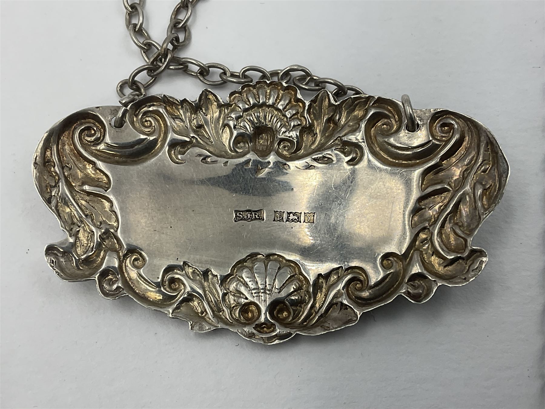 Five modern silver decanter labels, to include two sherry examples, embossed with scrolls and fruits, hallmarked W I Broadway & Co, Birmingham 1991 & 1997, a similar claret example, hallmarked S J Rose & Son, Birmingham 1973, and two plain shaped port and burgundy examples, hallmarked C Robathan & Son, Birmingham 1997 and A Haviland-Nye, London 1968