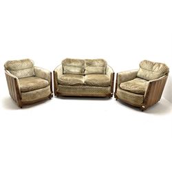 Art Deco oak framed two seat sofa upholstered in patterned fabric, supported on castors, (W120cm), together with two matching armchairs (W69cm)