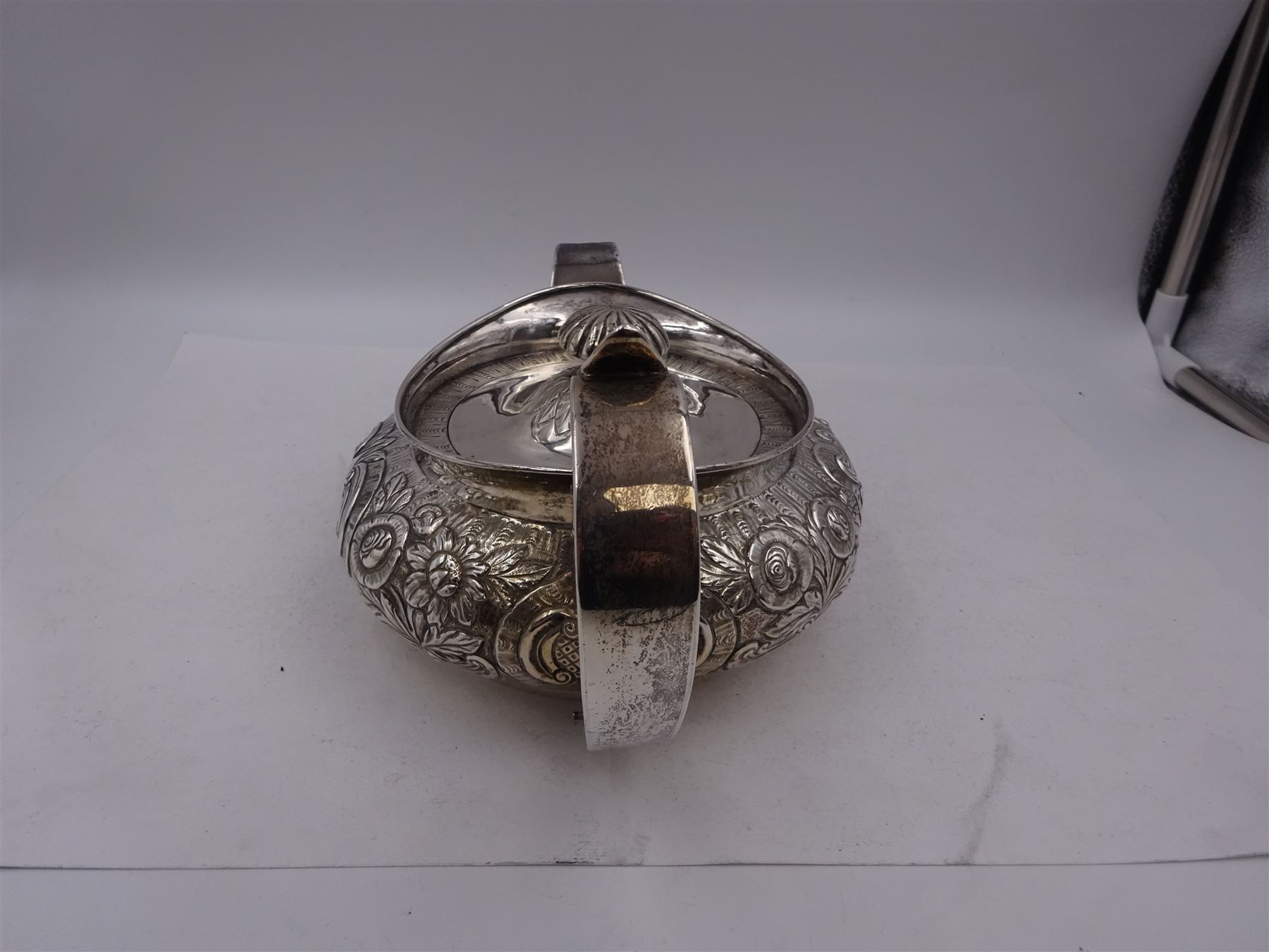 George III Irish silver teapot, of squat circular form, the body with repousse and chased floral and C scroll decoration, with capped C handle and ivory insulators, engraved to base 'Presented to Troop Sergeant Major John Percival, of the 4th Dragoon Guards by Alex D. Tait, Esq, late Captain in that corps as a mark of approbation of his steady and upright conduct when Sergeant Major of his Troop, Dublin, June 2nd 1843', hallmarked William Law, Dublin 1817, H12.5cm, This item has been registered for sale under Section 10 of the APHA Ivory Act