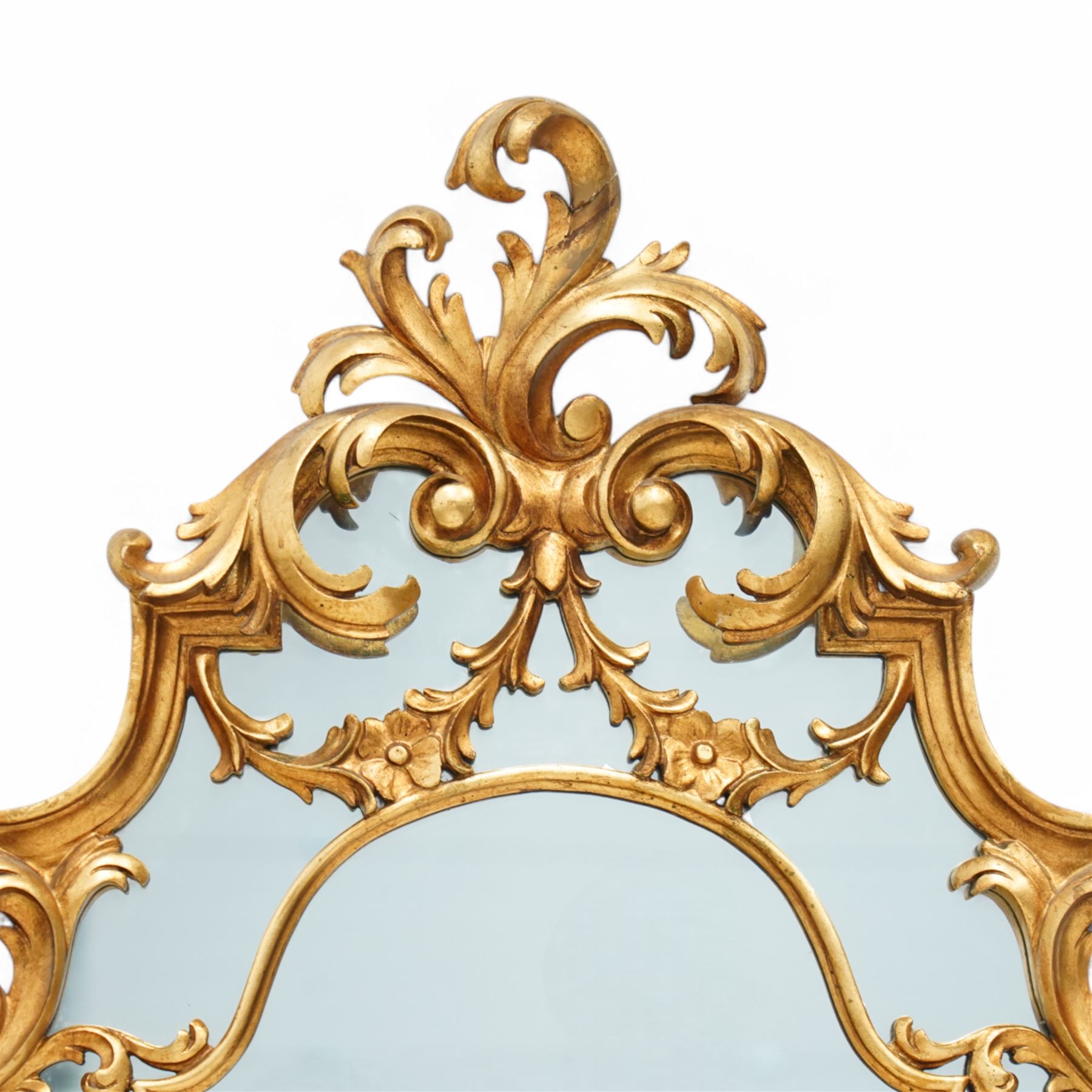 Rococo design carved gilt wood wall mirror, shaped and moulded frame decorated with scrolling leafage, plain mirror plate divided by mouldings