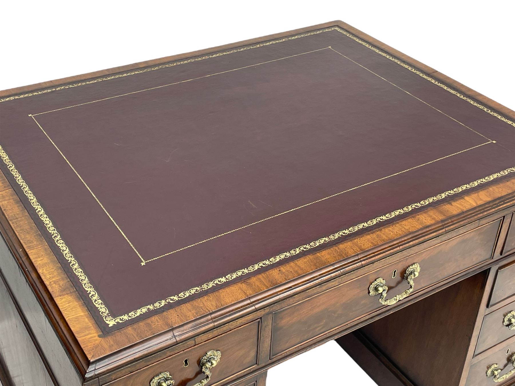 George III mahogany twin pedestal partner's desk, moulded rectangular caddy top with tooled leather inset, one side fitted with nine drawers and the opposing side fitted with single drawer, two false drawers and two panelled cupboards, ornate cast gilt metal handles and handle plates, on plinth base