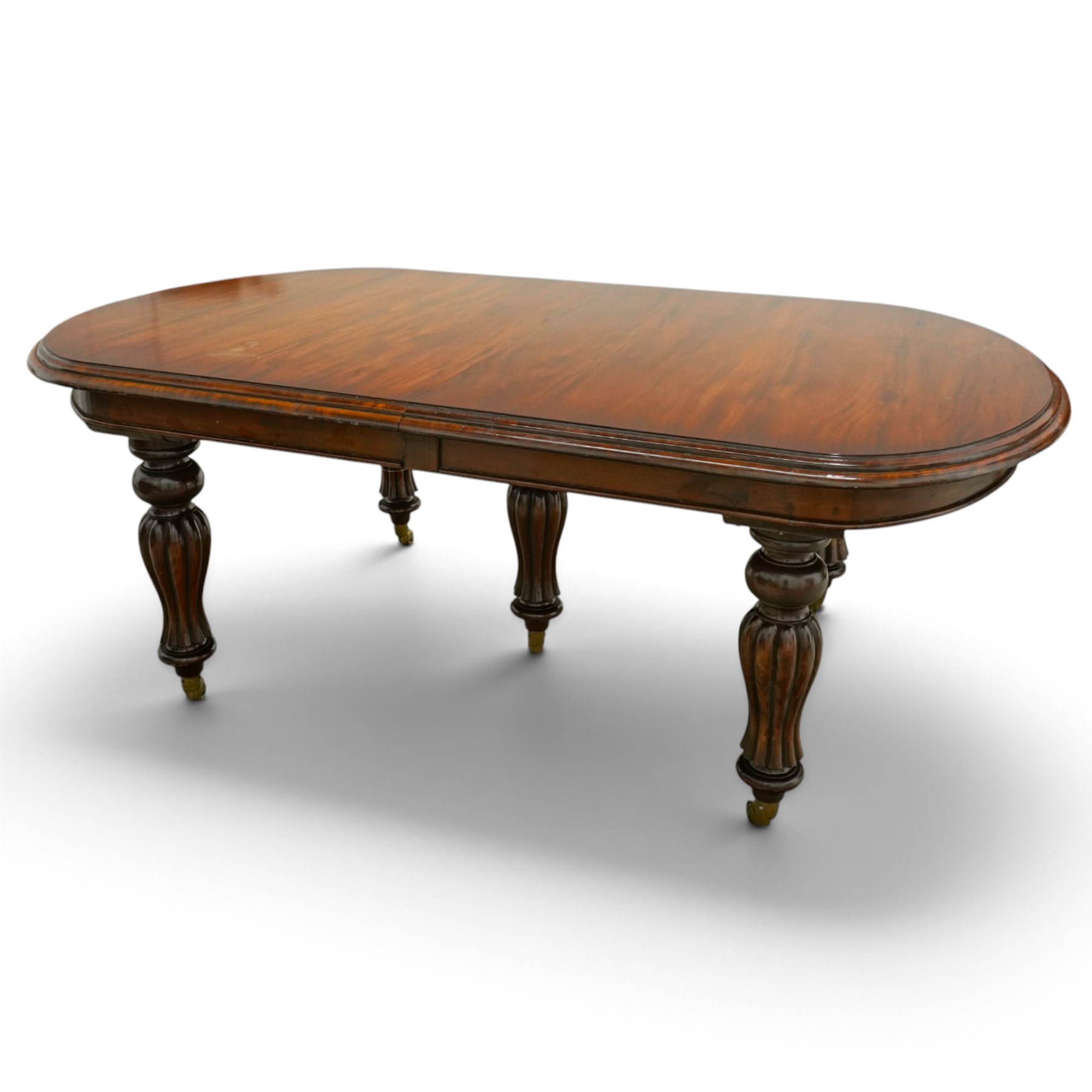 Large Victorian Country House mahogany extending dining table, the oval top with moulded edge over a plain frieze, raised on five large turned and reeded supports, with winding extending mechanism and additional leaf