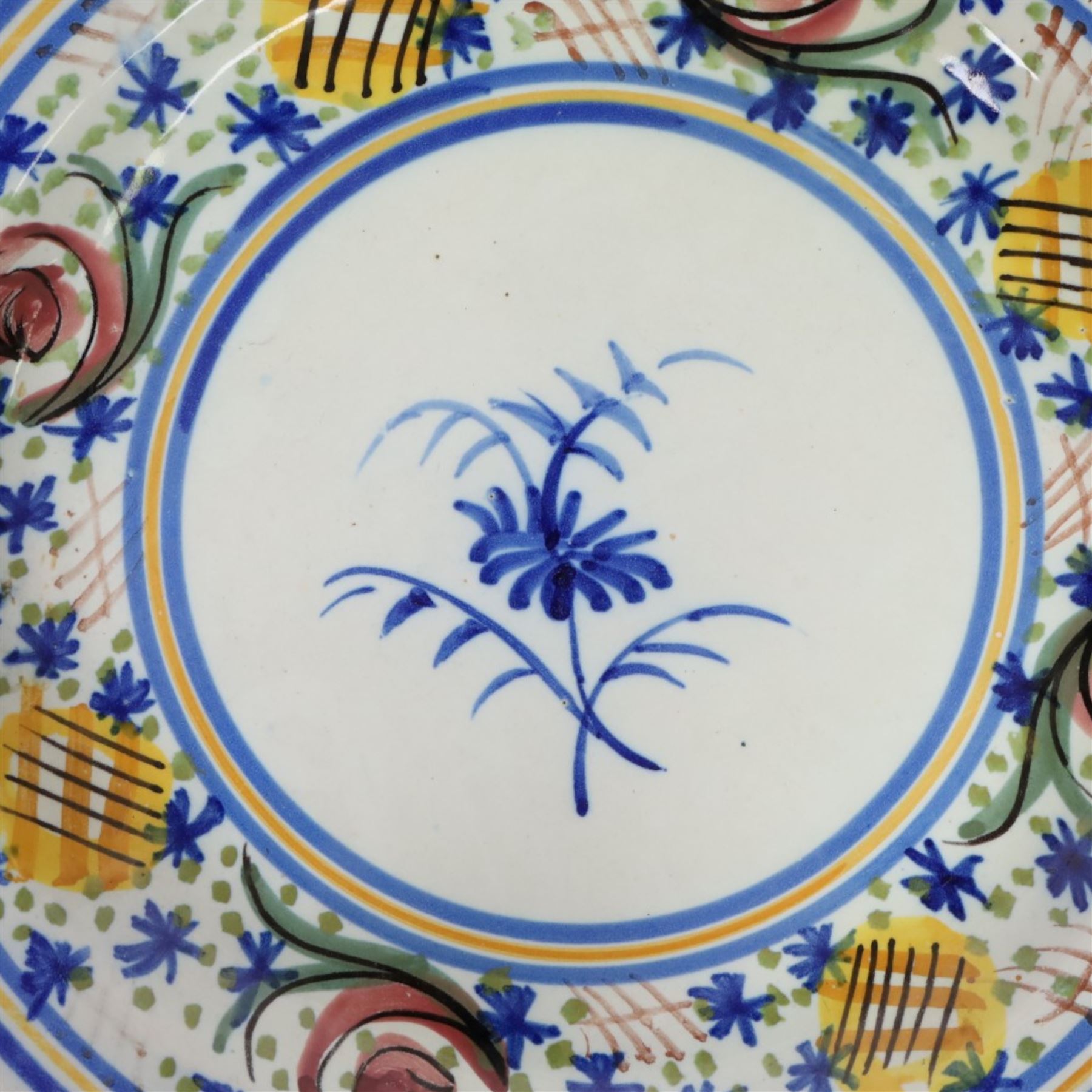 Pair of 20th century Spanish tin glazed polychrome plates, each painted with central foliate spray, within a stylised border, D32cm 