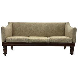 Victorian mahogany framed three-seat settee, upholstered in floral pattern fabric, on turned feet with brass and ceramic castors 