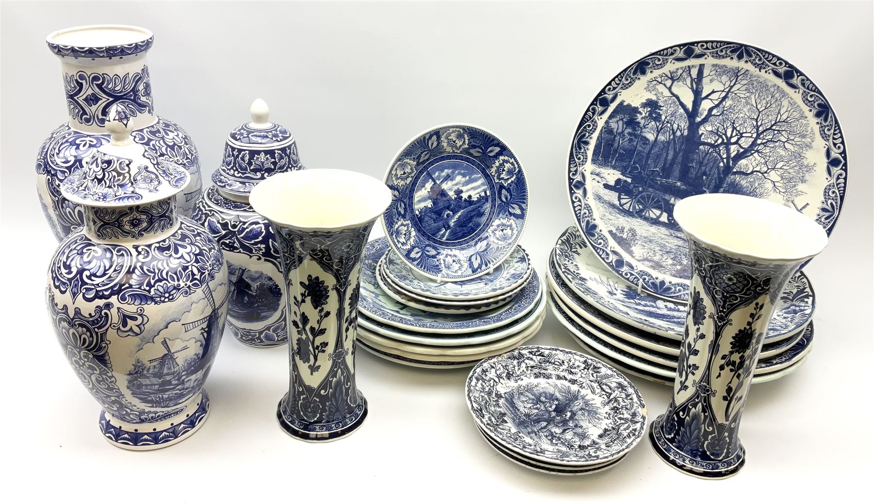 A large collection of modern transfer printed Delft ware, to include large baluster vase, H42cm, two jars and covers, largest H40cm, pair of tapering cylindrical vases, H31cm, and a number of plates of various size and design. 