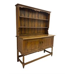 Early 20th century oak dresser, fitted with two cupboards and two-tier shelf plate rack, on turned supports united with box-stretcher