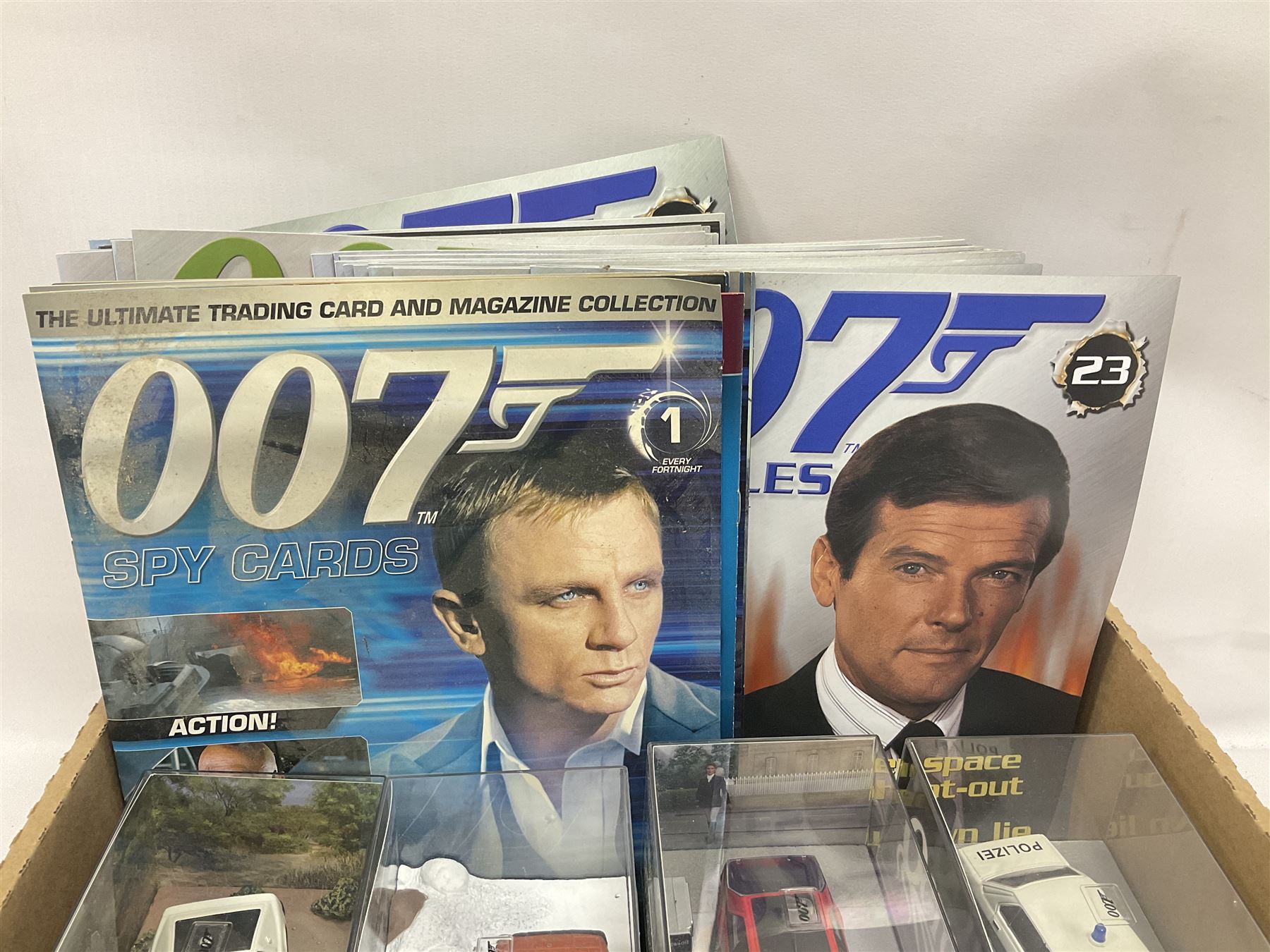 Fabbri James Bond Collection - over one hundred and ten die-cast models in perspex display cases as issued periodically; and a quantity of associated magazines and trading cards, in five boxes