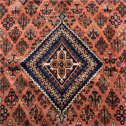 Joshgan Persian wool rug, with diamond-framed medallion, on a deep red field filled with geometric-shaped floral motifs and indigo-filled spandrels 