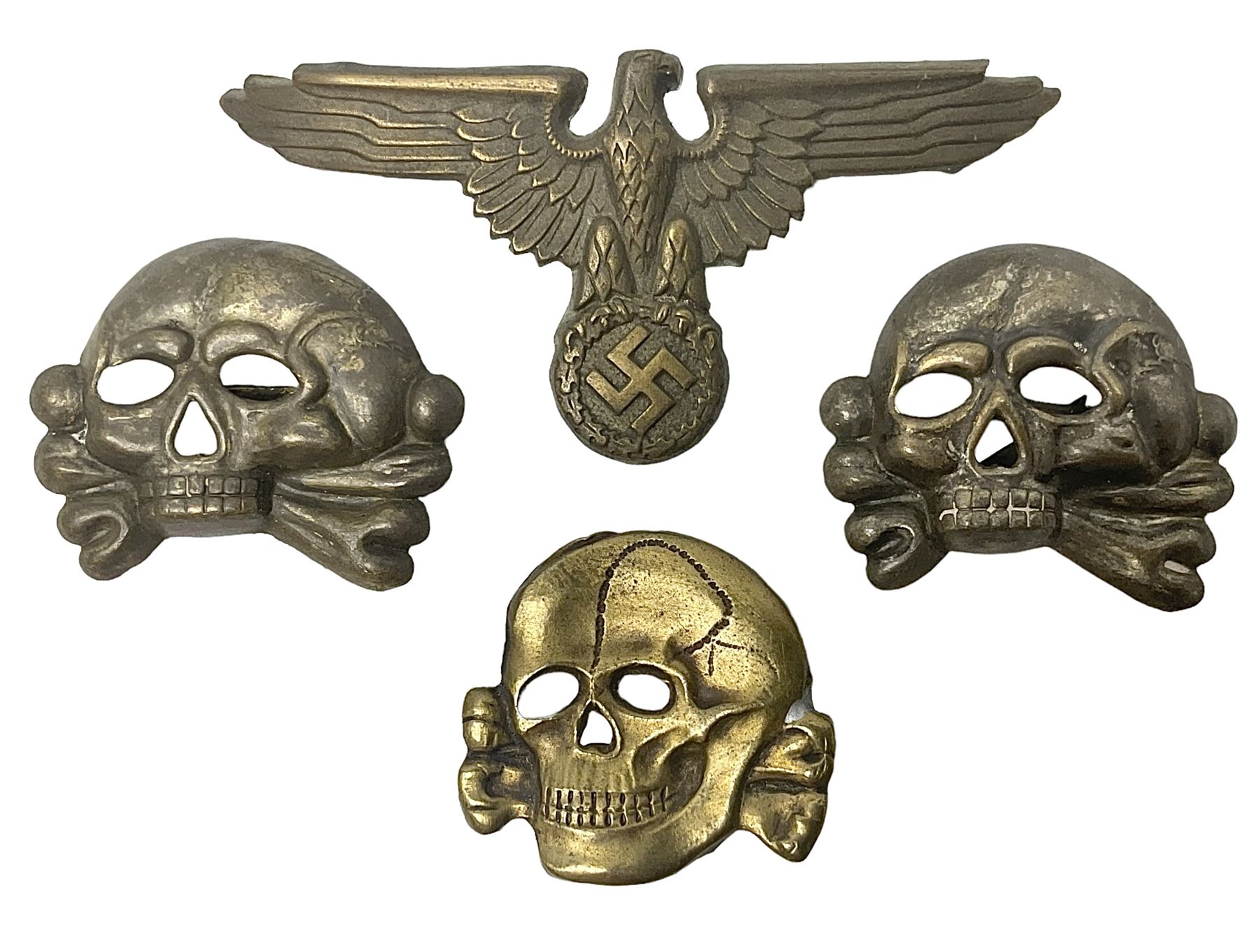 Two WW2 German 'SS' visor cap skull badges and another later; and visor cap eagle insignia (4)