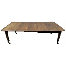 Early 19th century figured mahogany extending dining table, the rectangular top with moulded edge and rounded corners, pull-out action with three additional leaves, raised on turned and lobe carved supports with brass cup castors