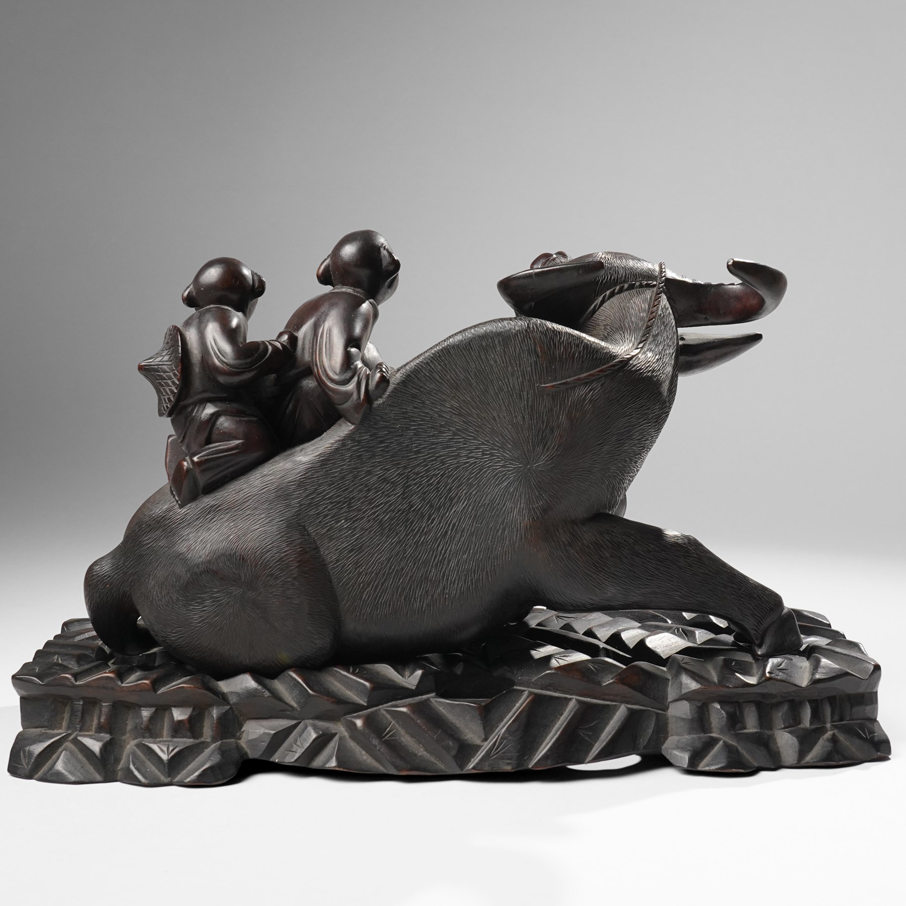Early 20th century Chinese carved hardwood figural group of two boys on the back of a water buffalo on wooden stand W37cm