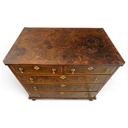 William & Mary period laburnum and walnut oyster-veneered chest, the rectangular top with canted corners and walnut banded edge, profusely decorated with oyster veneer and fruitwood stringing in concentric circles, fitted with two short over three long drawers with fruitwood banding, each fitted with original pressed brass escutcheons and pull handles, lower moulded edge over original bun feet