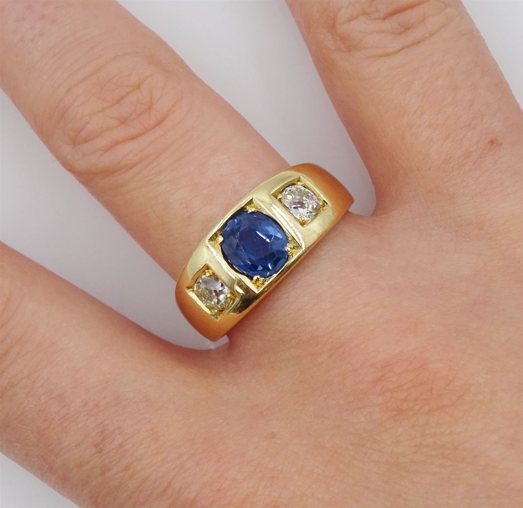 Late 19th century continental gypsy set three stone oval sapphire and old cut diamond ring, stamped 18ct, makers mark HA, total diamond weight approx 0.45 carat, sapphire approx 1.05 carat