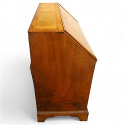 18th century walnut and herringbone banded bureau, the fall front enclosing a stepped and arched interior fitted with pigeonholes, drawers and concealed compartments, green tooled leather writing surface, over two short and three long graduated drawers with brass escutcheons and bail handles, shaped bracket feet