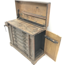 Late 19th century work bench tool cabinet, hinged lid enclosing tool rack, single vice, six graduating drawers, storage cupboards at both ends, inlaid Melhusih plaques,  shaped plinth base by Richard Melhuish & Sons, London(W107cm, H88cm, D50cm) and a quantity of hand tools
