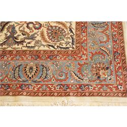 Persian Isfahan ivory and crimson ground rug, the busy field with central floral pole medallion surrounded by foliate motifs and stylised palmettes, the indigo guard line with repeating scrolling plant motifs