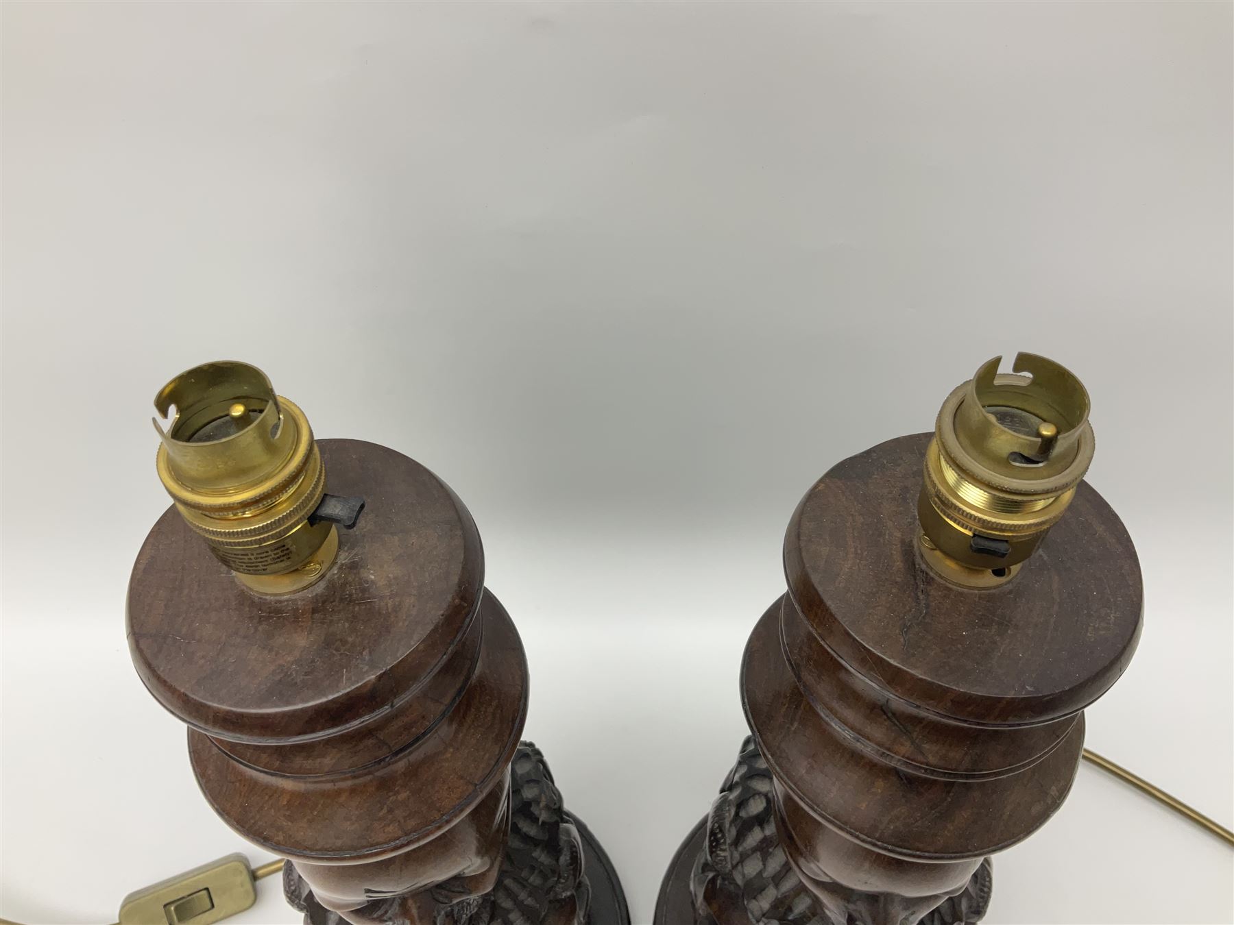 Pair of 20th century carved wood table lamp with African busts and figures, together with a carved wooden figure and soapstone figure, lamps H44cm