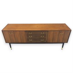G Plan - ‘Librenza’ tola wood sideboard, the rectangular top above two cupboards to either side and three graduated central drawers, the drawer and door fronts veneered in figured tola wood with brass handles, standing on splayed tapering legs