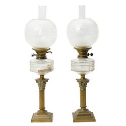 Pair of Victorian table oil lamps with clear glass reservoirs on brass Corinthian columns ...