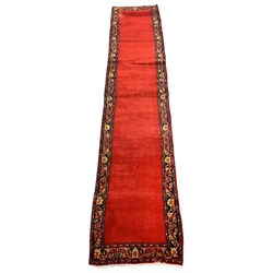 Persian Tabriz runner rug, plain red ground field, trailing stylised foliage and flower head border, 405cm x 79cm
