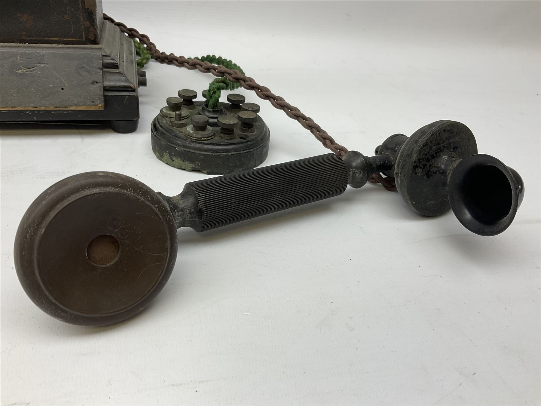 Early 20th century Danish desk telephone inscribed The Ericsson Bell Telephone Co. Glasgow to one side and Aktieselskabet Electrisk Bureau Kristiansand to the other, ebonised wooden top with handset on brass cradle. black japanned tin centre section bearing Hull Corporation Telephones Department crest, side cranking handle and ebonised wooden base H30cm  