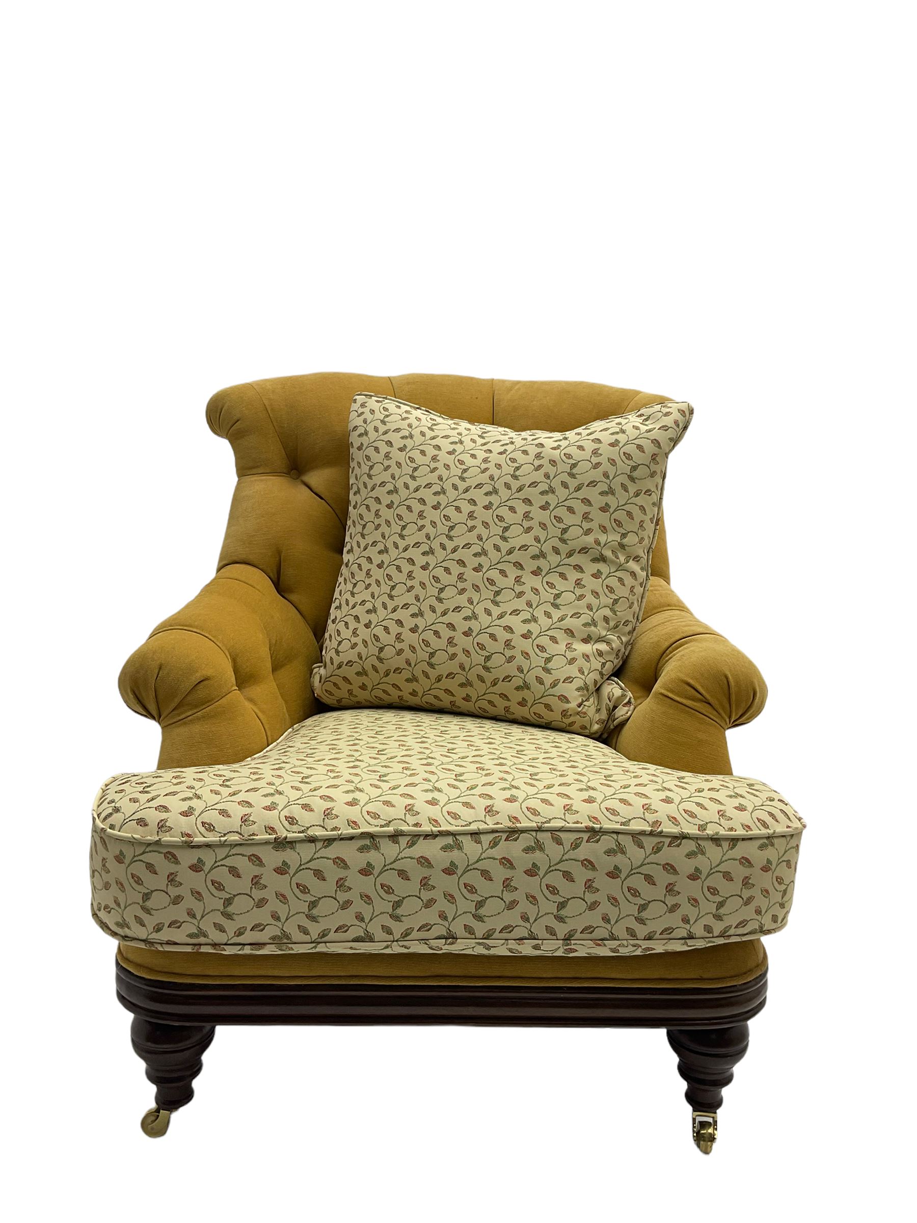 Victorian style armchair, upholstered in buttoned fabric with contrasting foliate pattern seat and scatter cushion, on turned front feet with castors