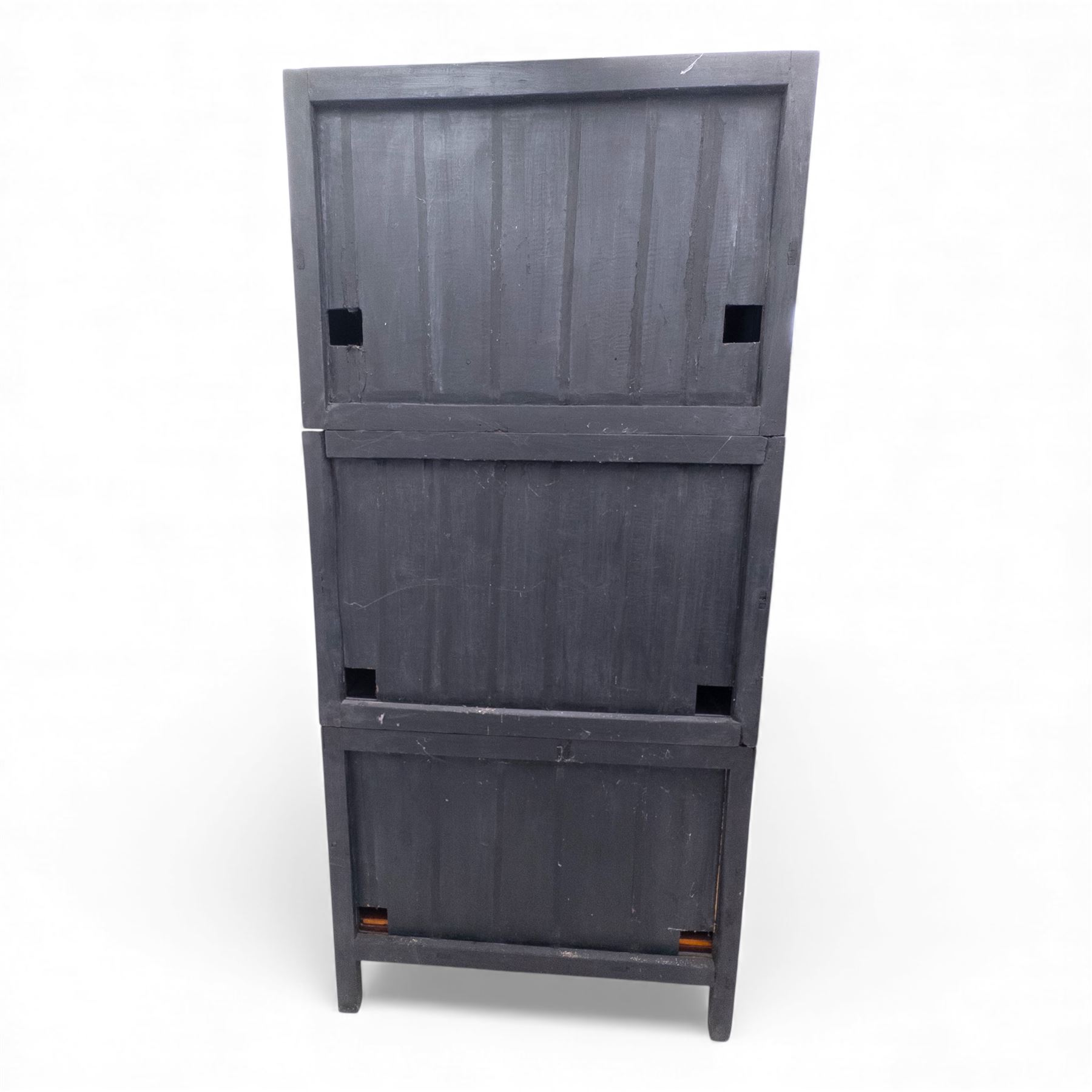 20th century Thai elm compound cabinet, formed of three stacking chests each enclosed by double panelled doors with decorative wrought metal lock plates and hinges, raised on pierced apron on stile feet