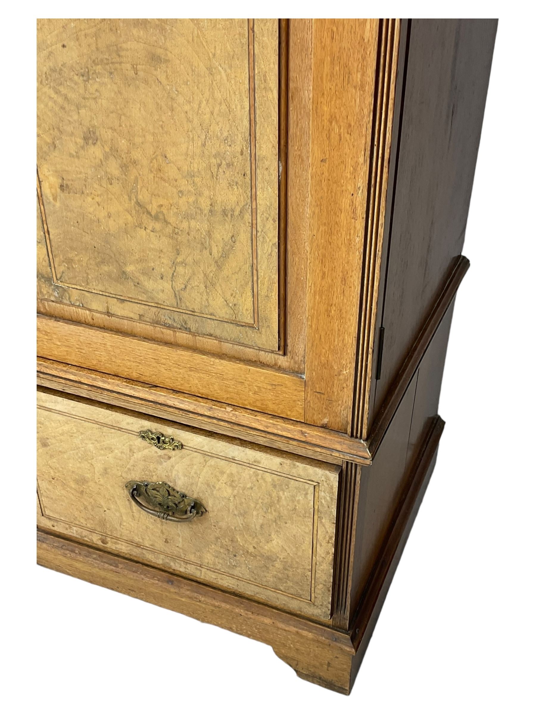 Late Victorian walnut triple combination wardrobe, projecting moulded and dentil cornice, central shaped bevelled mirror glazed door, cartouche and curled leaf carved panels over figured walnut veneered panels, fitted with drawer to base, on bracket feet