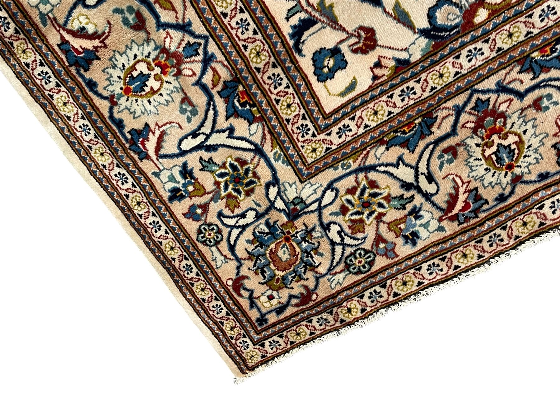 Persian Kashan ivory ground carpet, the field decorated with scrolling branches with foliate and palmette motifs, repeating border with stylised plant motifs, within floral and geometric pattern guard stripes 