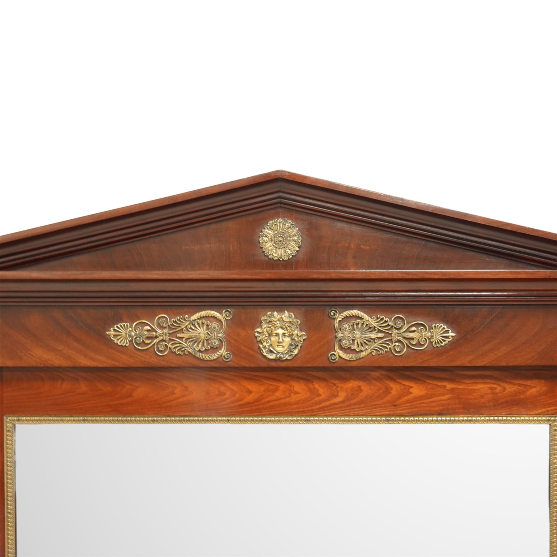 Rare pair of French Second-Empire neoclassical style mahogany mirrors with ormolu mounts, architectural pediment with central ormolu patera above flame mahogany frieze with honeysuckle flower and caryatid mounts, the frame with ormolu beading and bevelled mirror plates, flanked by turned columns with ormolu mounts above a reverse breakfront base, circa 1870