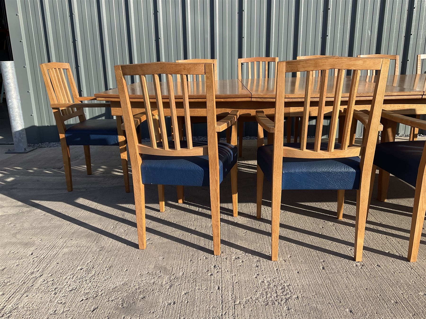 Light oak bespoke boardroom table, concave form, four sectional top on square discreet legs (12' x 5'), with twelve armchairs including 'Chairmans' chair