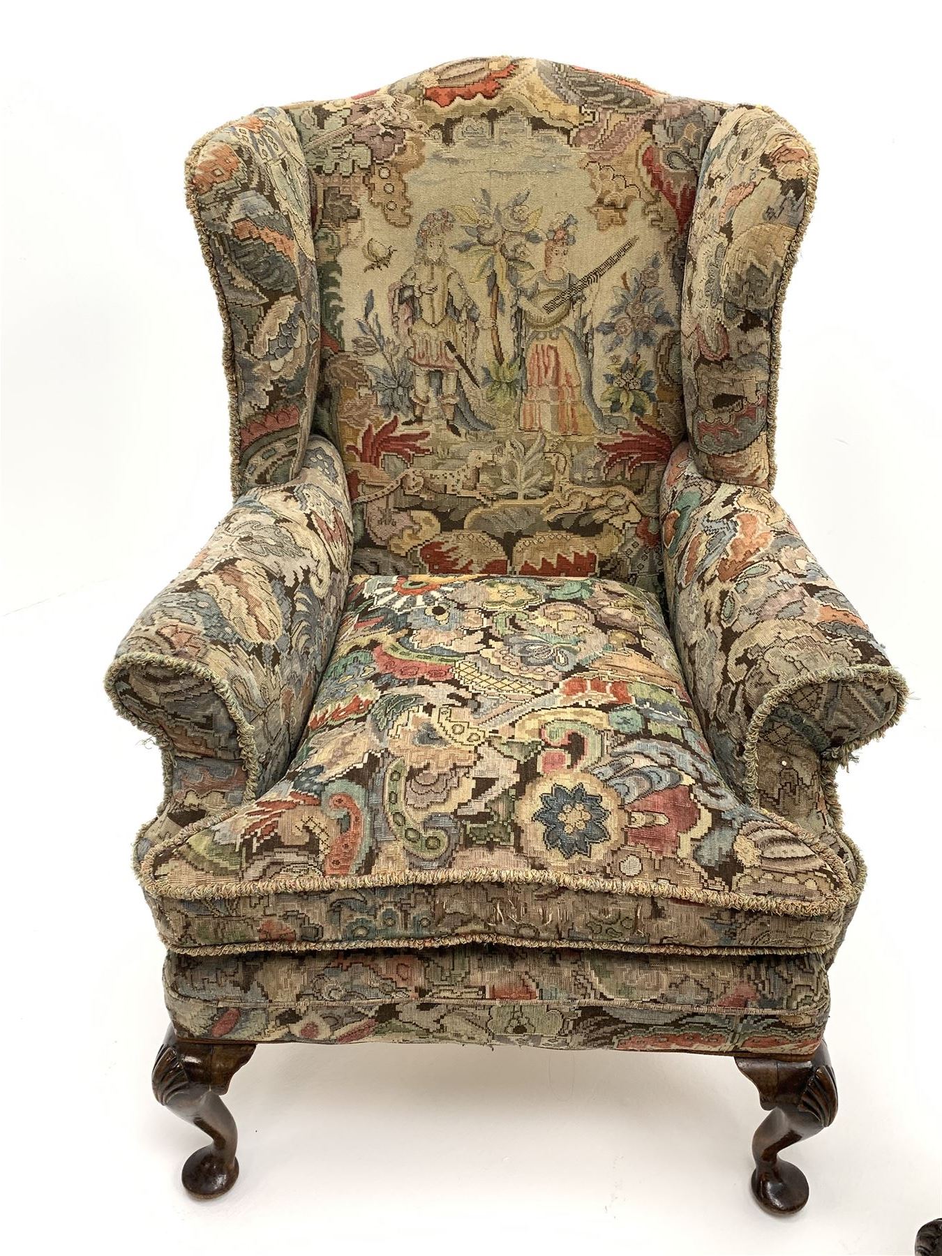 Matched pair early 20th century Queen Anne style wingback armchairs, walnut framed, sprung seats with seat cushions upholstered in needle work cover, shell carved cabriole front feet