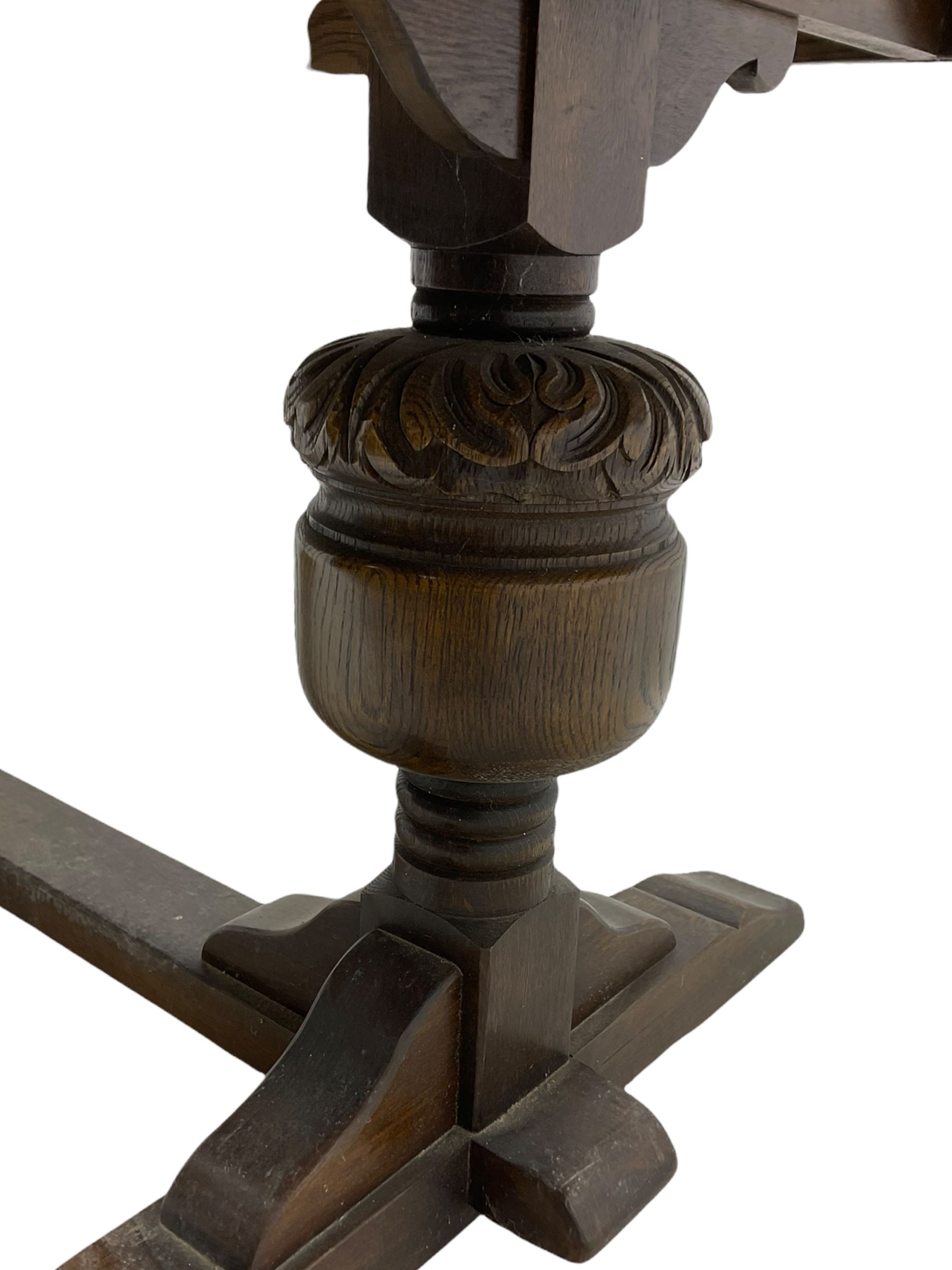 20th century oak drawer leaf extending dining table, two foliage carved baluster supports on sledge feet joined by floor stretcher 