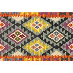 Chobi flatweave kilim runner with a repeating stepped diamond medallion design in live green, rust, teal, purple, and ivory, framed by chevron and geometric borders