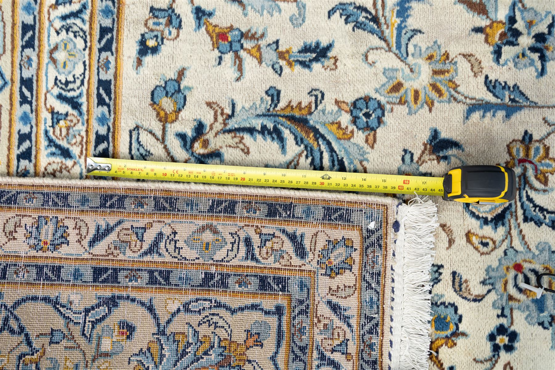 Central Persian Kashan hand-knotted carpet, ivory field profusely decorated with an all-over scrolling vine, palmette, and lotus design in shades of soft blue, pale gold, and green within floral borders