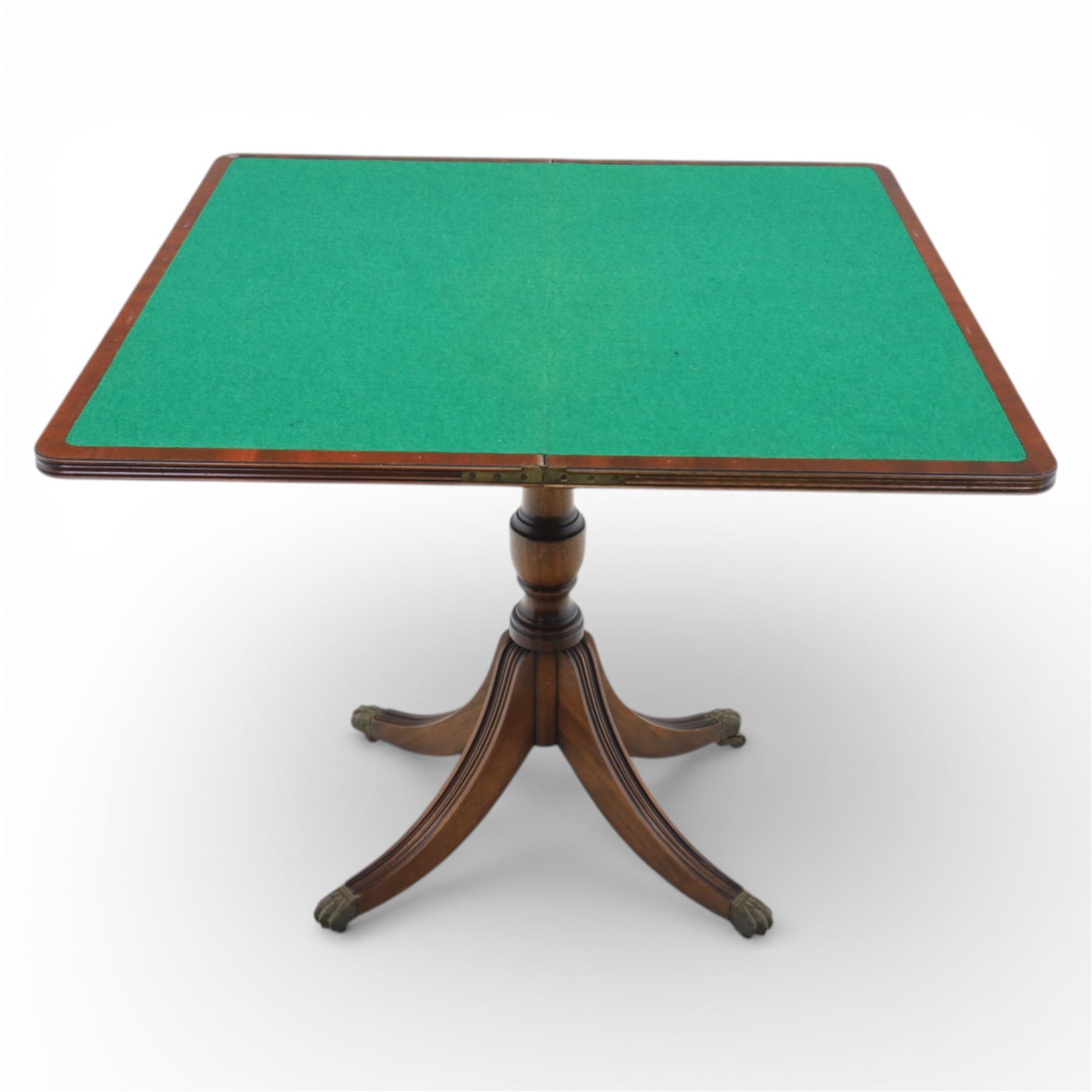 Victorian design mahogany card table, rectangular top with swivel and fold open action, revealing a baized lined interior, raised on turned baluster column, with reeded legs terminating in brass paw castors 