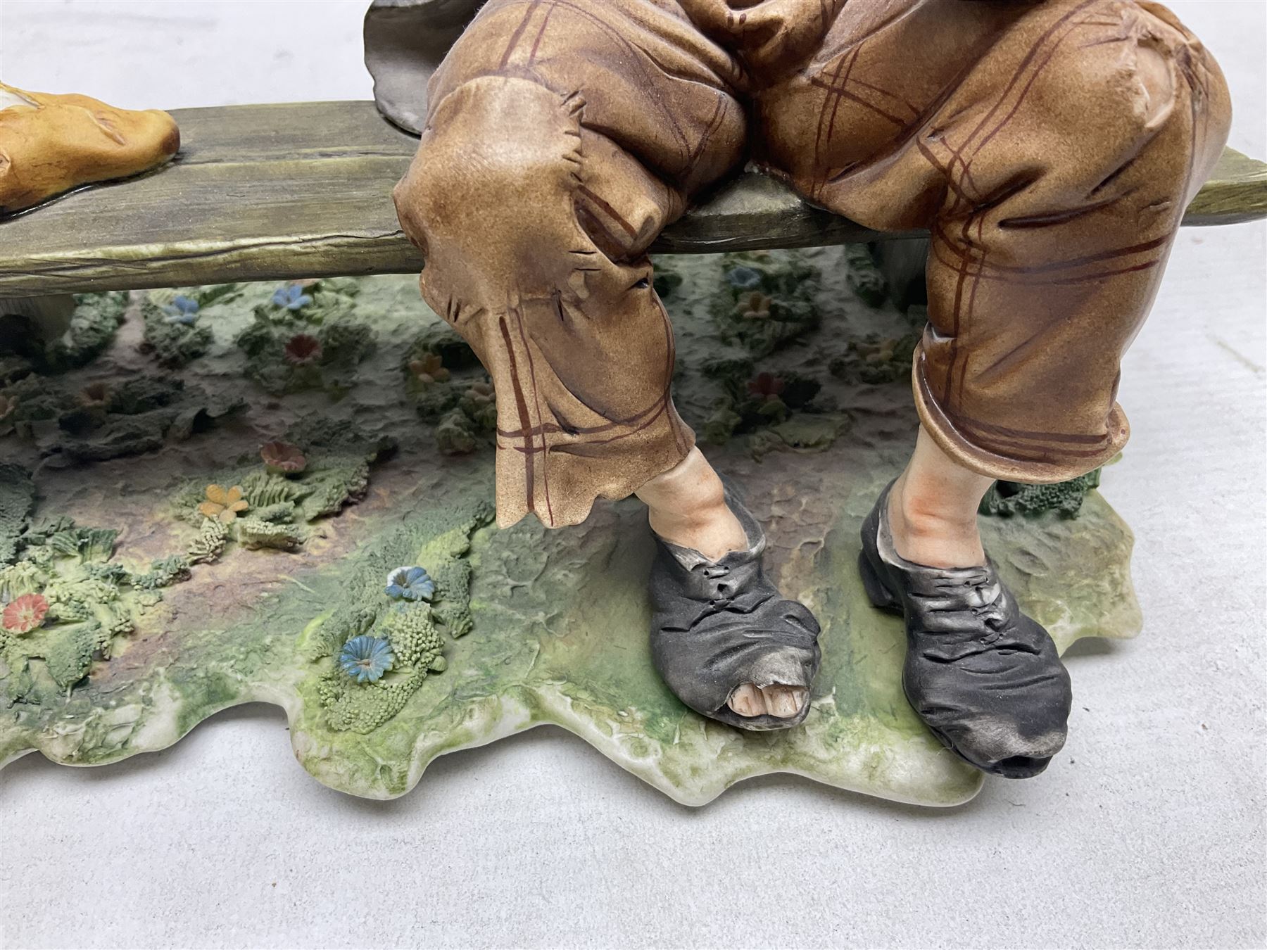 Two Capodimonte figures, comprising The Watchmaker by Curiase and Tramp Seated on a Bench, created by D.Bonalberti, tallest example H24cm