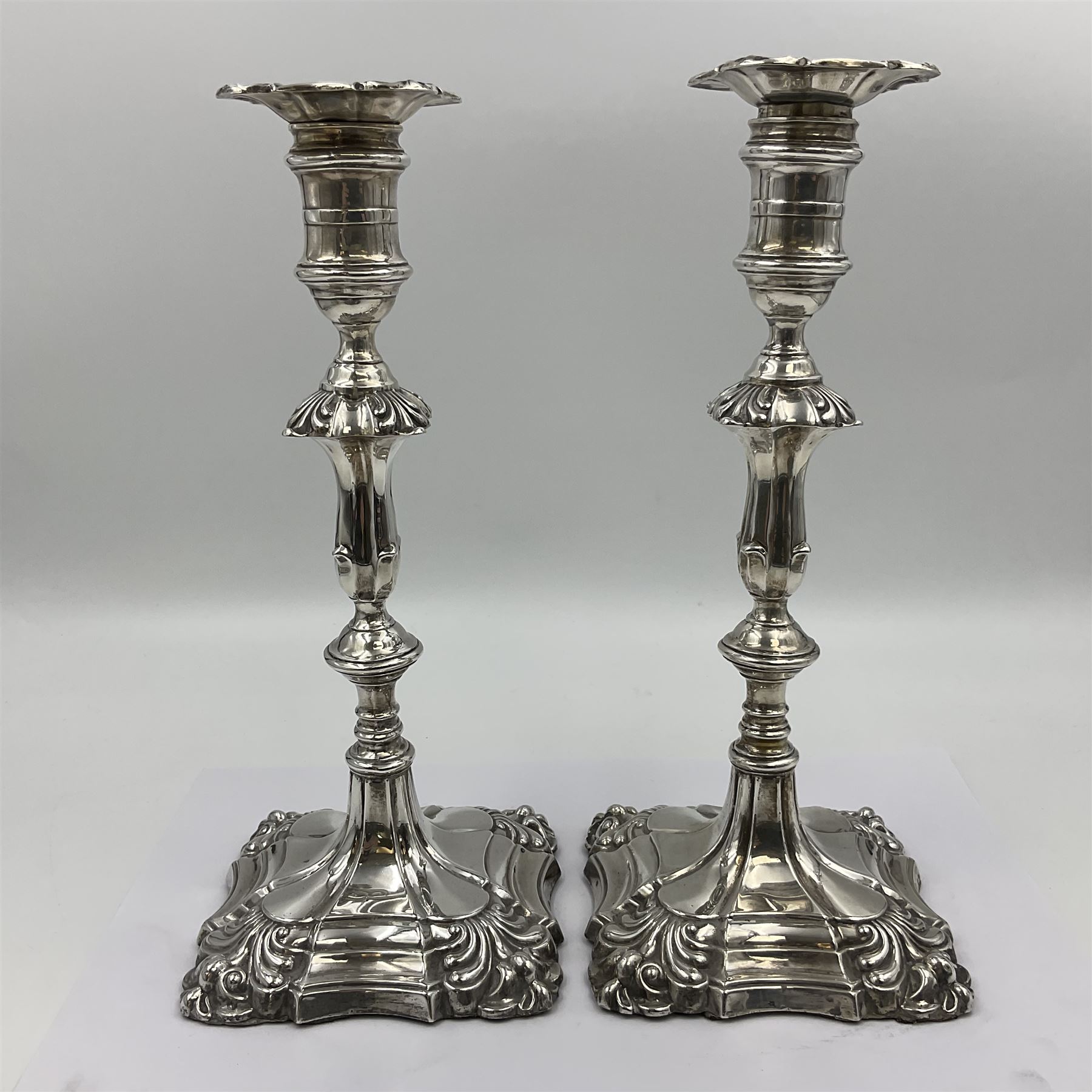 Pair of late Victorian silver mounted candlesticks, each of knopped and part fluted form, upon square stepped base with anthemions to each corner, with conforming sconces, hallmarked to removable sconces and foot, Thomas A Scott, Sheffield 1901, H25.2cm